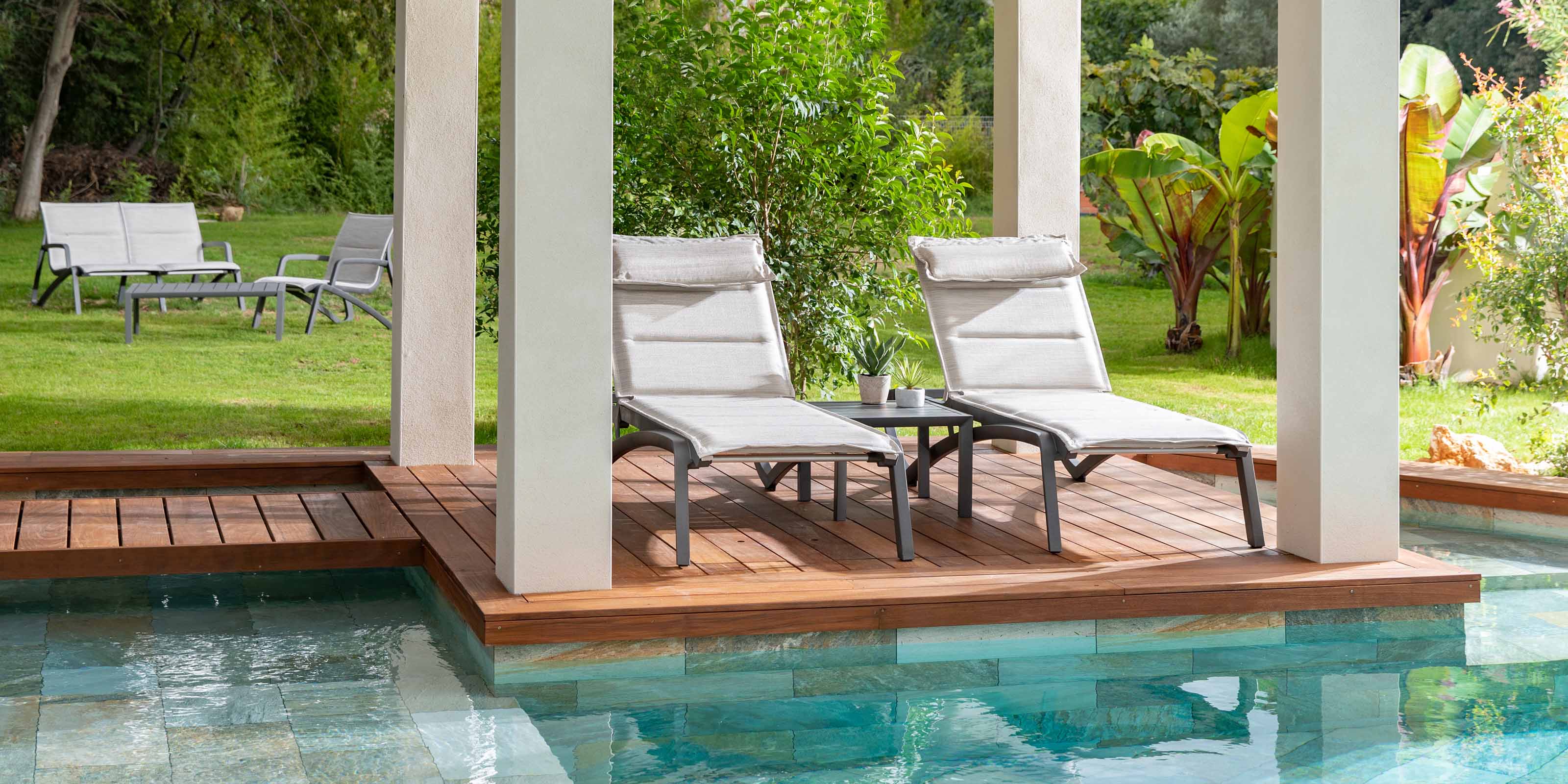 An image of two chaise lounges by a pool