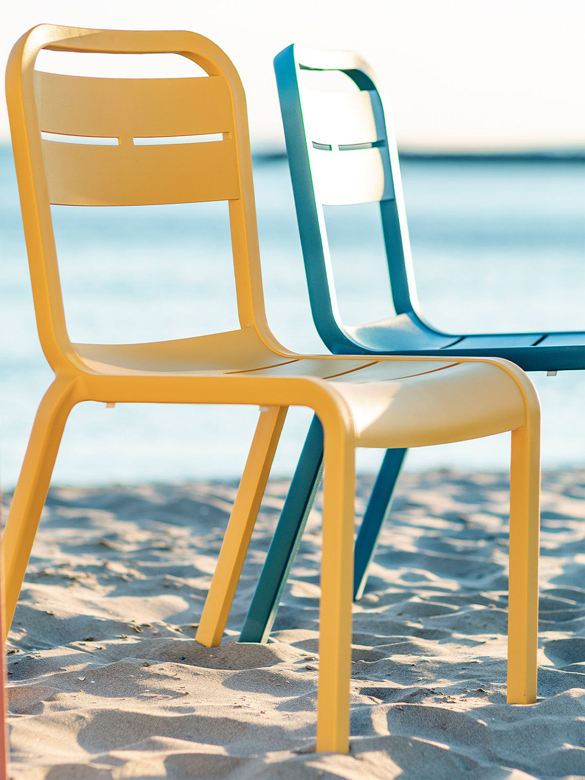 Cannes Chairs sit on the beach by the ocean