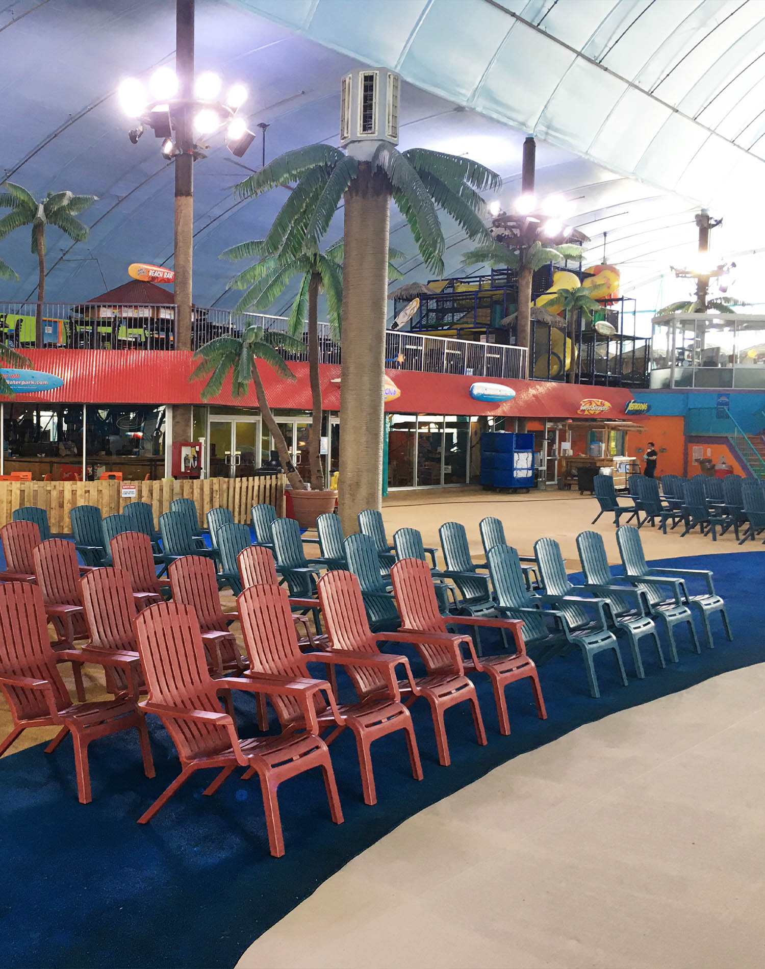 A group of Westport Adirondack chairs fill out the pool deck area at an indoor waterpark