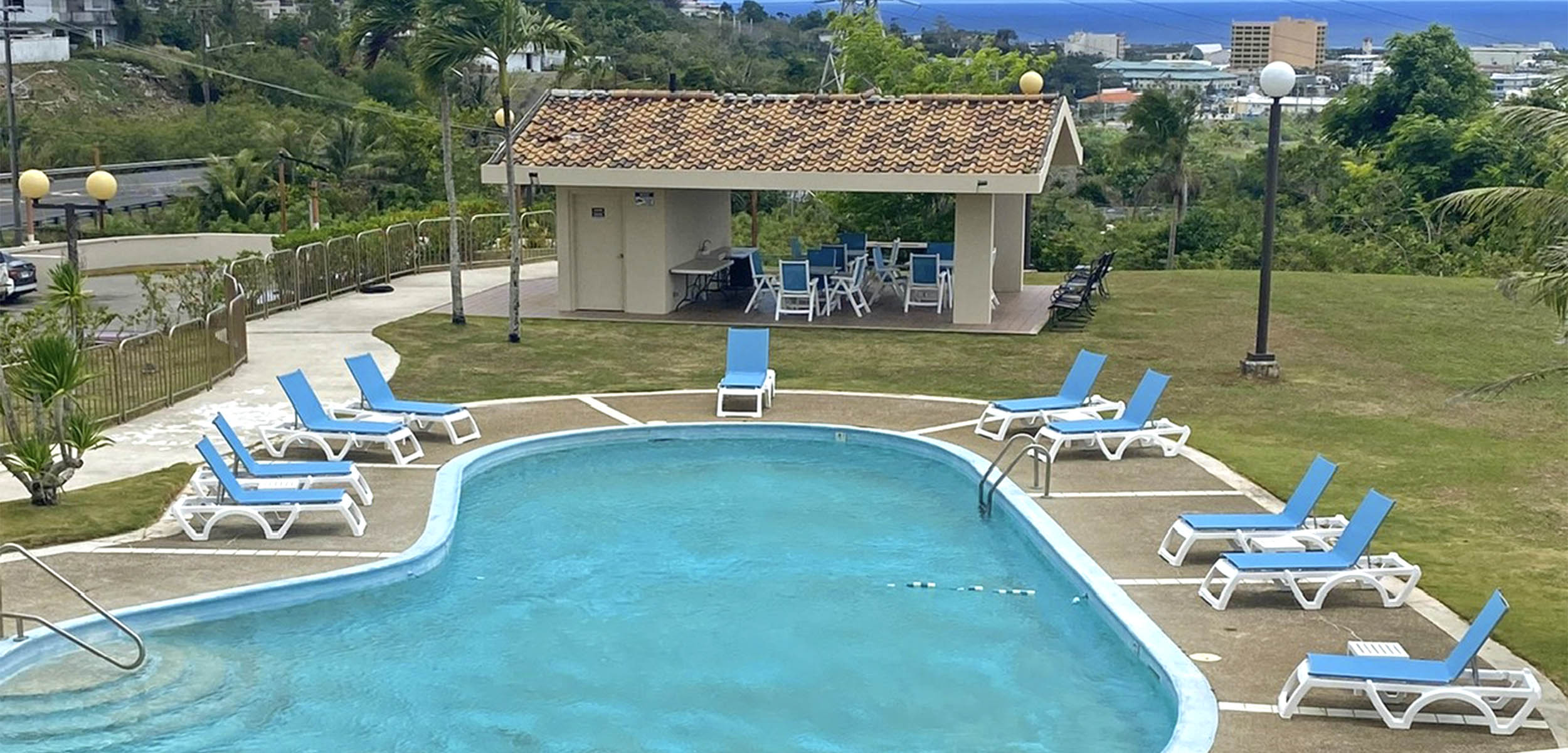 Chaise Lounges by Grosfillex fill the pool deck at the Holiday Tower Condos in Guam