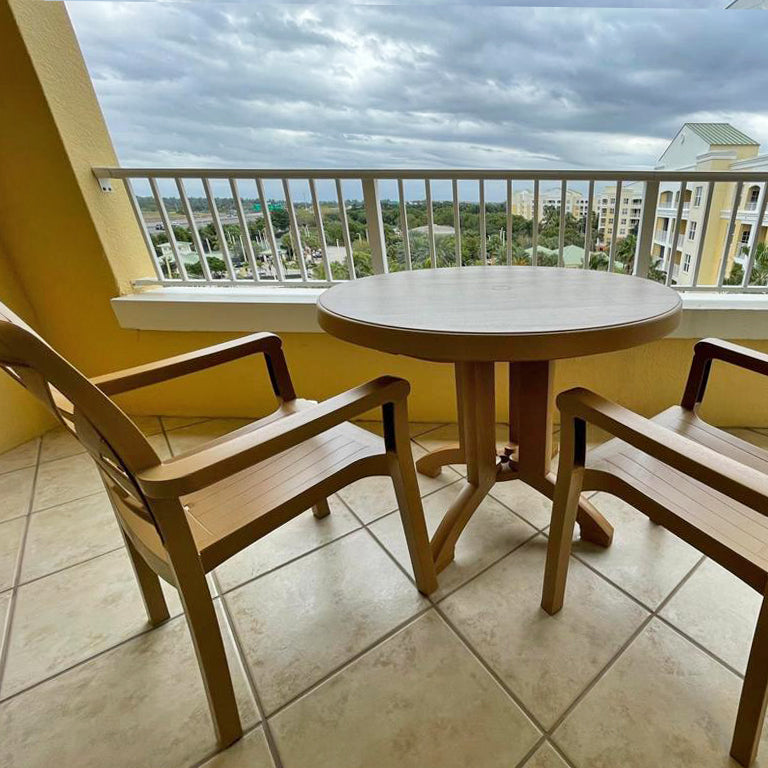 An angled shot of the Aquaba Table and Sanibel Armchairs