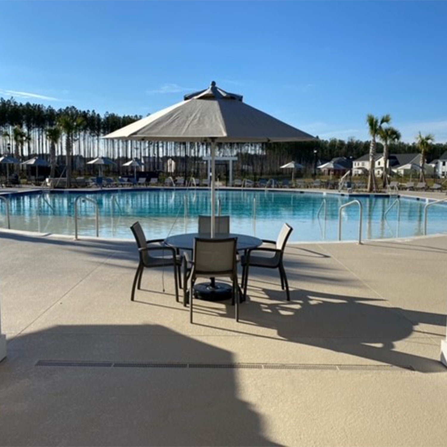 A straight on shot of the Sunset Armchairs around a table and umbrella