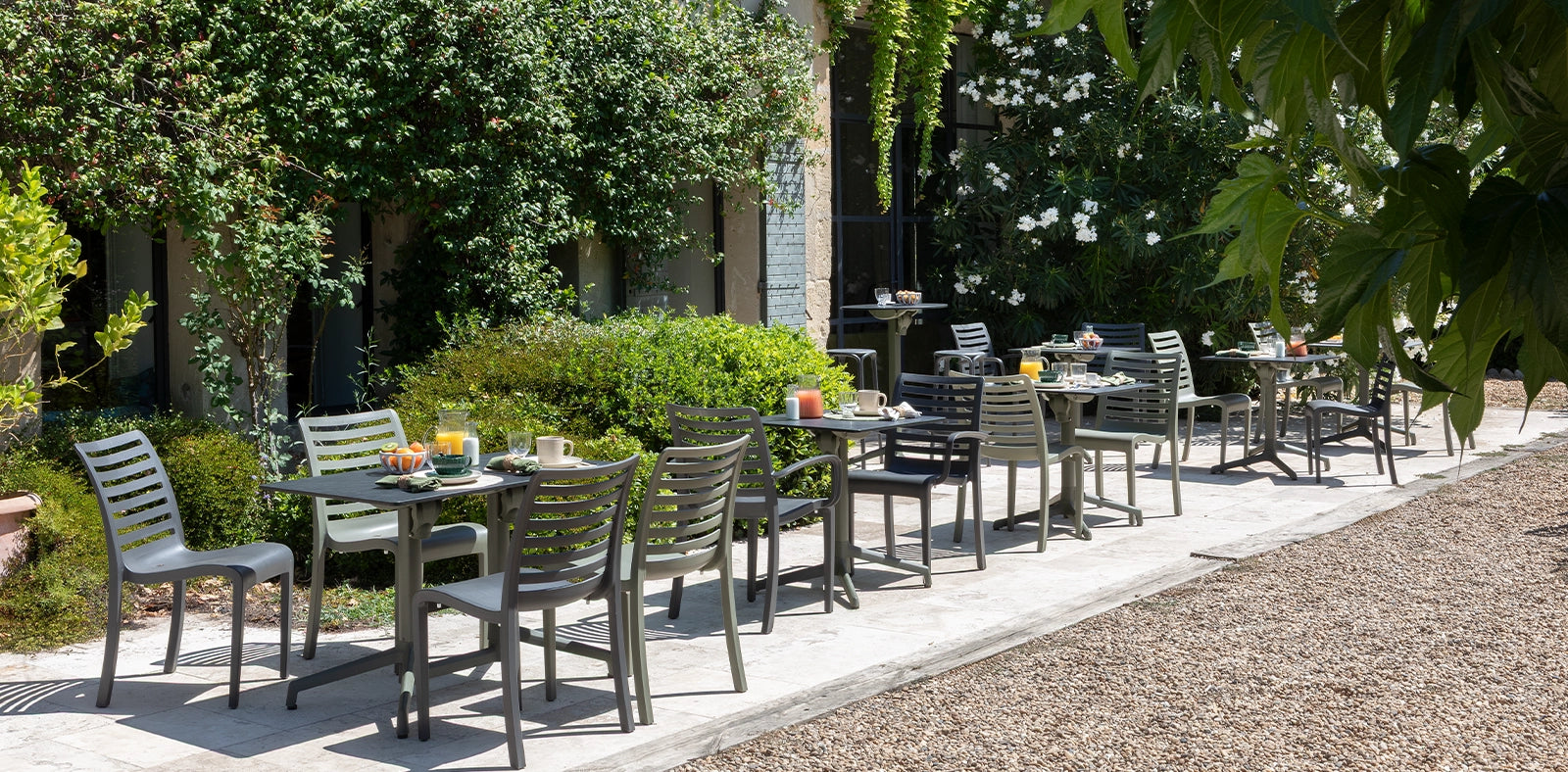 Outdoor dining area with tables and chairs in a garden setting