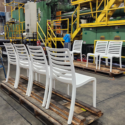 A lineup of newly manufactured Grosfillex slatted resin chairs after production 