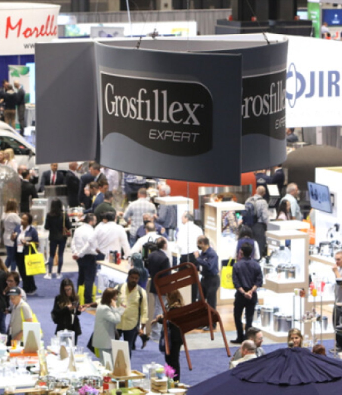 A Grosfillex sign hangs above the booth at a trade show event